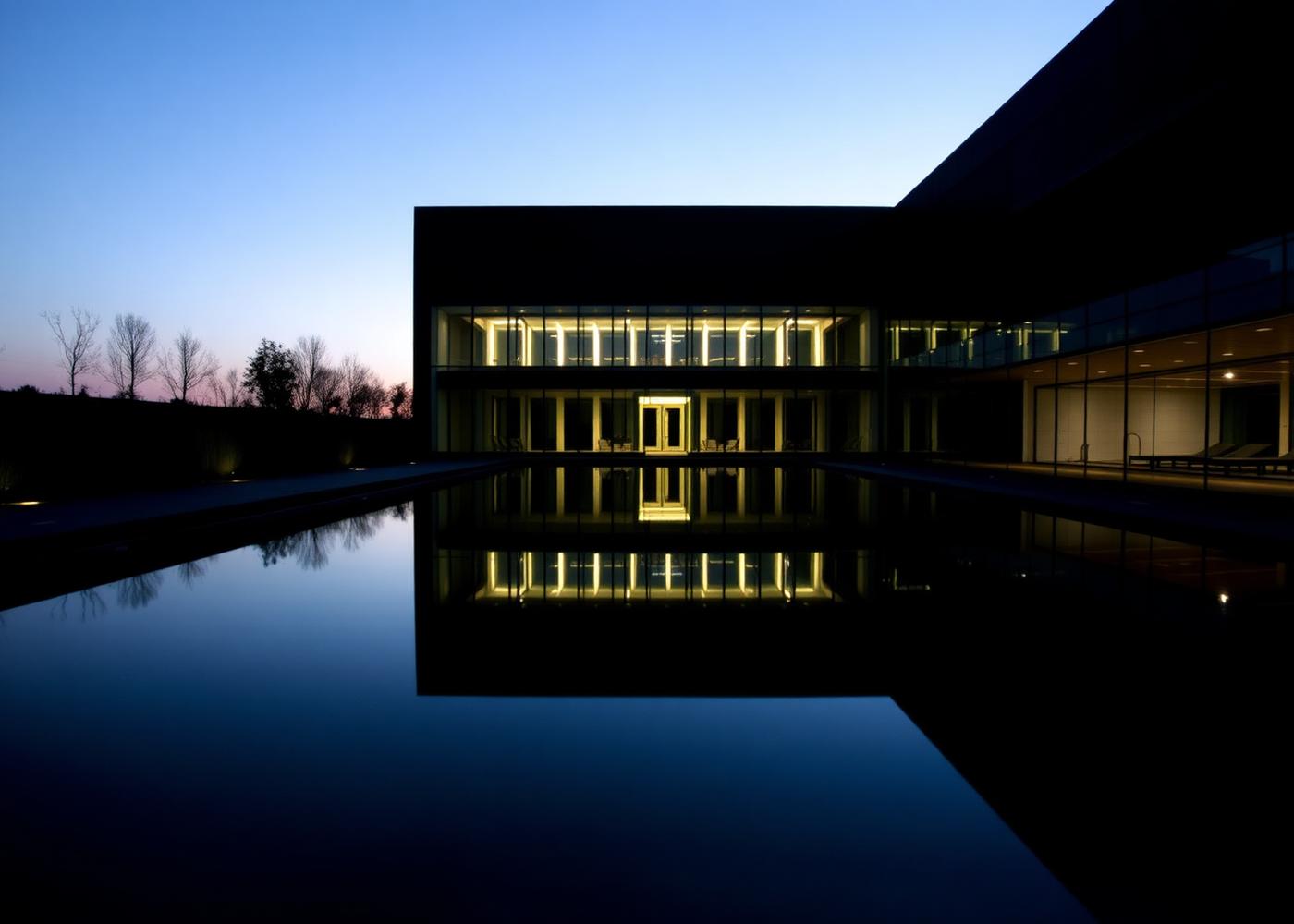 Still reflecting pool at dusk with subtle underwater lighting