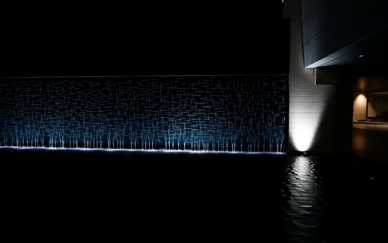 Architectural water feature wall lit from below at night